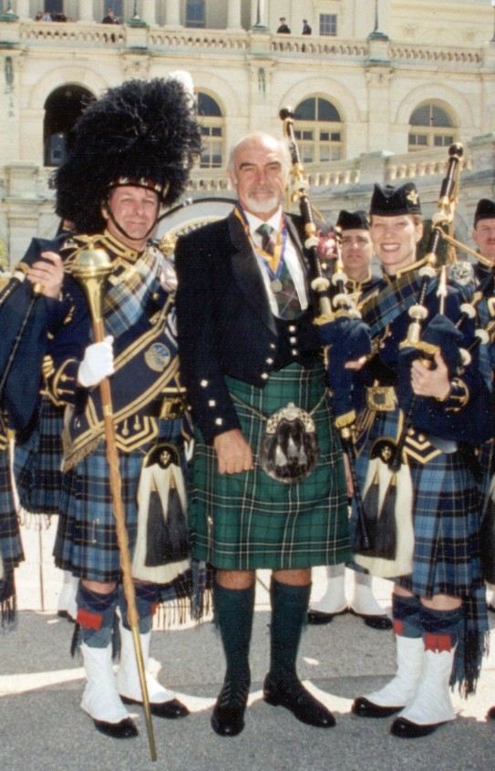 Sean Connery wearing a green tartan kilt with a United States Air Force pipe band